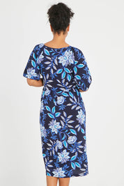 Model Noli wearing size 14 of the Can Go Everywhere Dress in colour Navyfleur (Blue), from the back