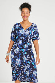 Model Noli wearing size 14 of the Can Go Everywhere Dress in colour Navyfleur (Blue), from the front, cropped image