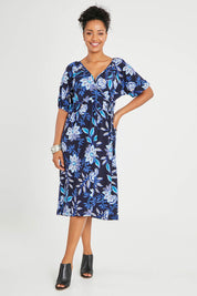 Model Noli wearing size 14 of the Can Go Everywhere Dress in colour Navyfleur (Blue), from the front, showing the whole outfit