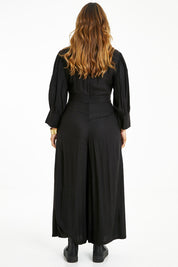 Model Laura wearing size 14 of the Feeling Super Fine Jumpsuit in colour Black (Black), from the back