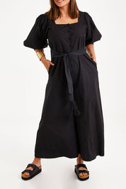 Model Monique wearing size 14 of the Big Love Cotton Jumpsuit in colour Black (Black), from the front, cropped image