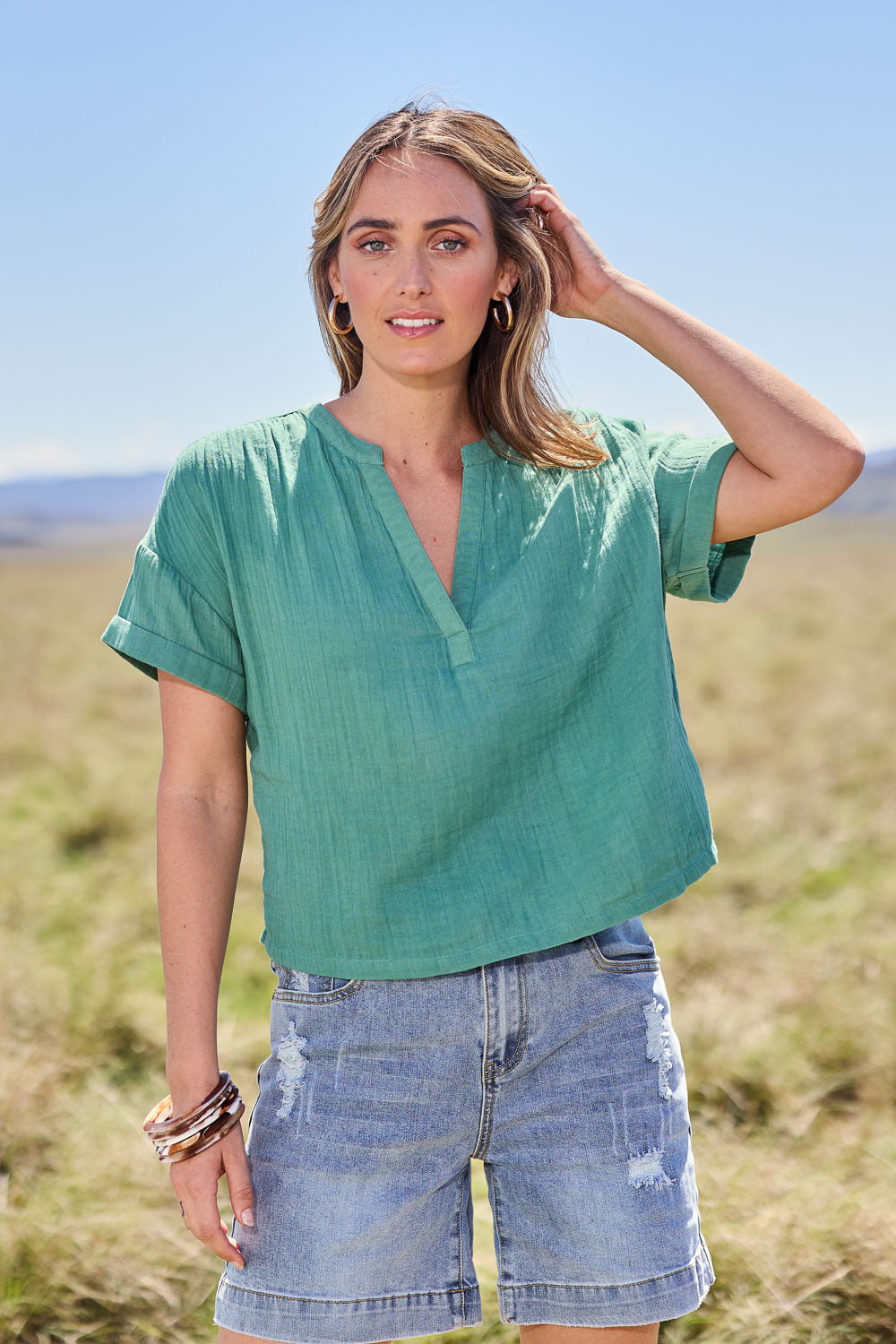 Model Tegan wearing size 10 of the Every Other Day Cotton Blouse in colour Sage (Green), from the front, showing the whole outfit