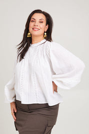 Model Poppy wearing size 16 of the My Fair Lady Blouse in colour White (White), from the front, cropped image