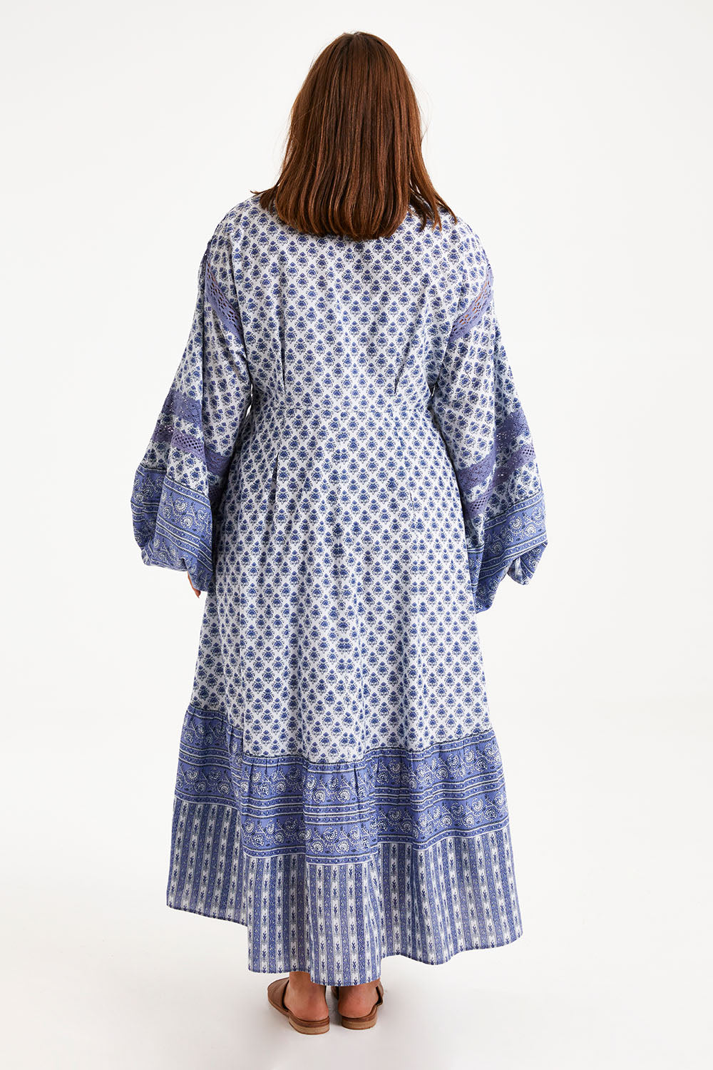 Model Monique wearing size 14 of the Under A Blue Sky Maxi Dress in colour Bluefleur (Blue), from the back