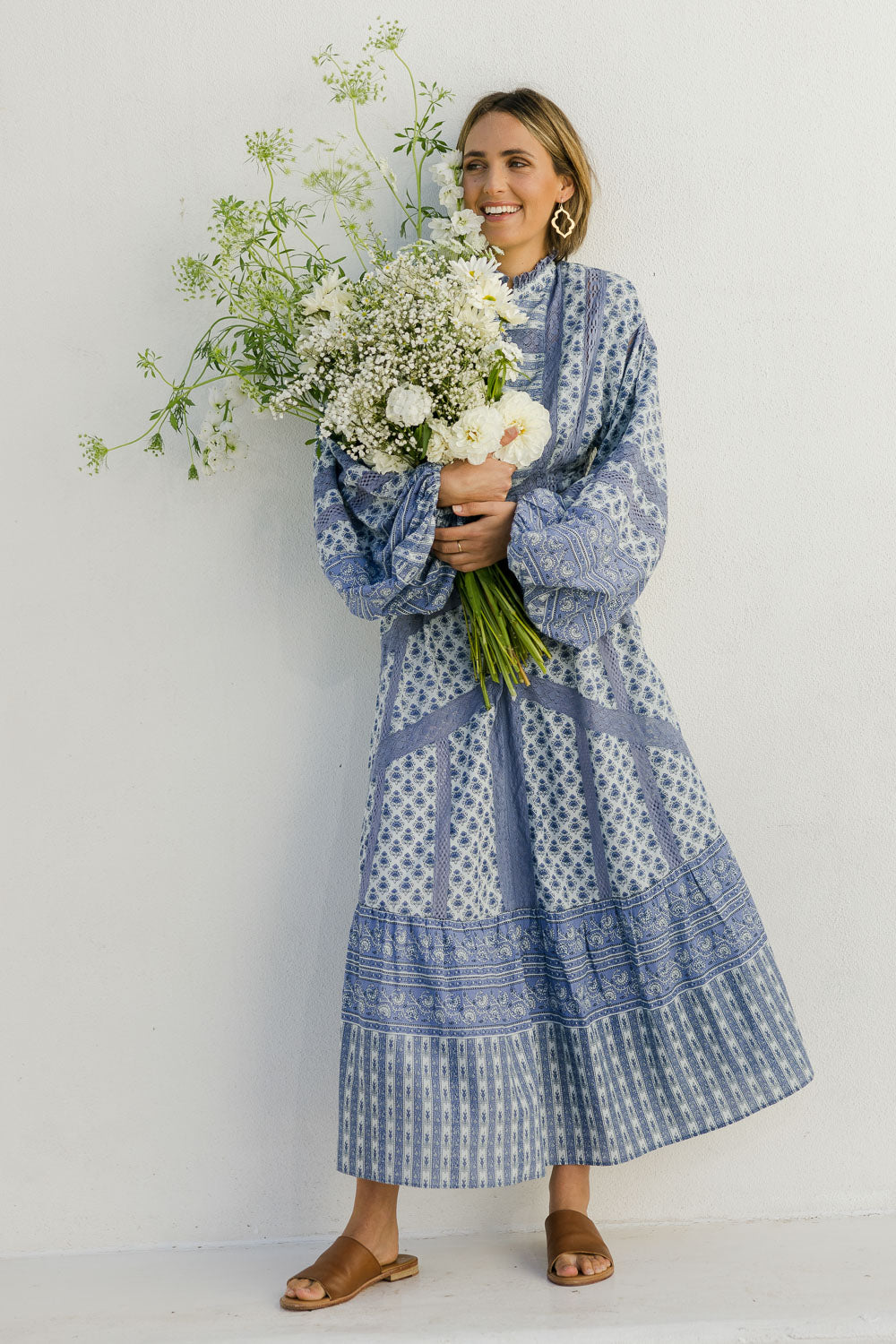 Model Tegan wearing size 10 of the Under A Blue Sky Maxi Dress in colour Bluefleur (Blue), from the front, showing the whole outfit