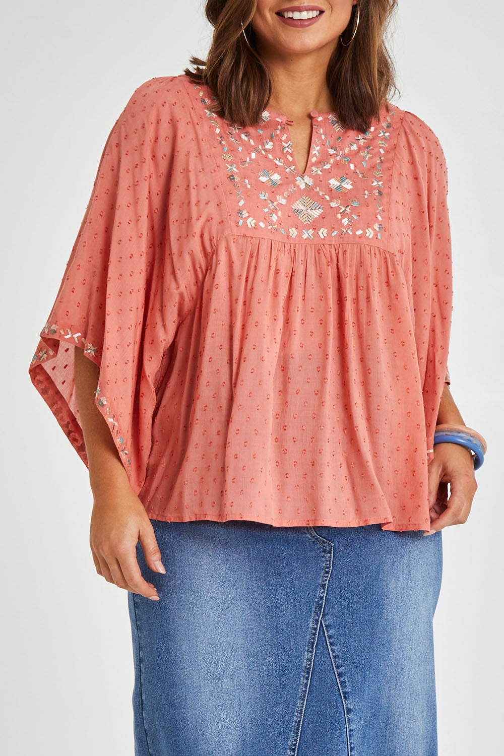 Model Monique wearing size 14 of the Simple Things Embroidered Top in colour Peach (Pink), from the front, cropped image