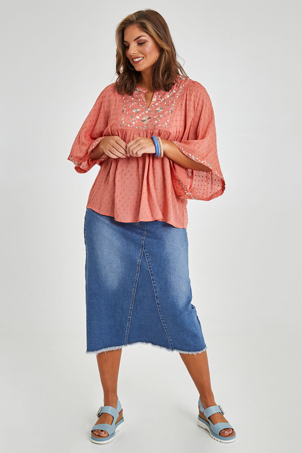 Model Monique wearing size 14 of the Simple Things Embroidered Top in colour Peach (Pink), from the front, showing the whole outfit