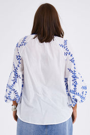 Model Monique wearing size 14 of the Feel My Vibe Embroidered Blouse in colour Whiteblue (White), from the back