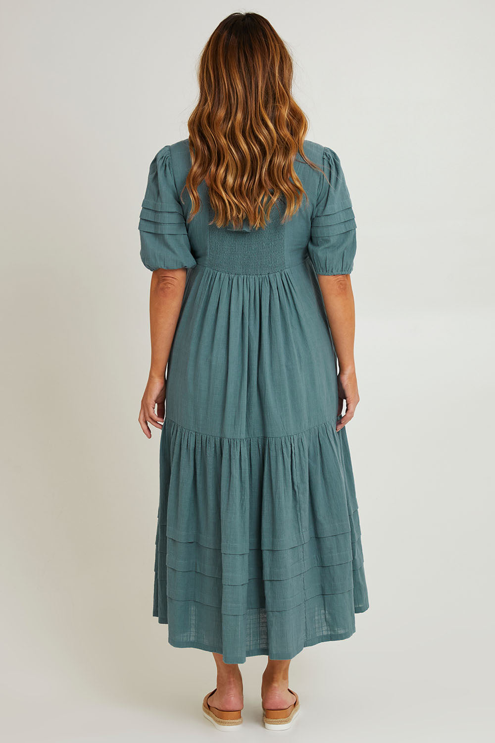 Model Laura wearing size 14 of the Chasing Butterflies Cotton Dress in colour Sage (Green), from the back