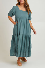 Model Laura wearing size 14 of the Chasing Butterflies Cotton Dress in colour Sage (Green), from the front, cropped image