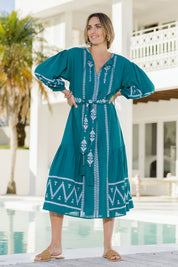 Model Tegan wearing size 10 of the Spring Fling Embroidered Dress in colour Jade (Green), from the front, showing the whole outfit
