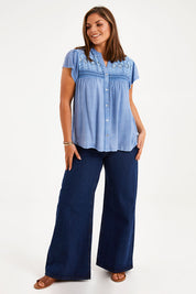 Model Monique wearing size 14 of the Floral Fields Embroidered Top in colour Chambray (Blue), from the front, showing the whole outfit