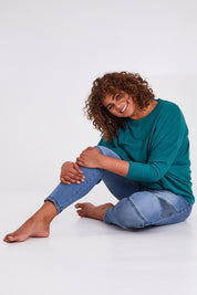 Model Anucia wearing size L of the Chill Vibes Slouch Top in colour Jade (Green), from the front, showing the whole outfit