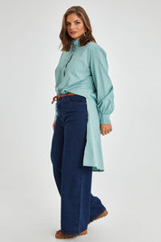 Model Monique wearing size 14 of the Ringmaster Of My Life Shirt in colour Sage (Green), from the front, showing the whole outfit