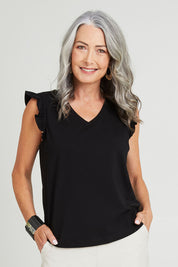 Model Luisa wearing size 10 of the For The Frill Of It Tee in colour Black (Black), from the front, cropped image