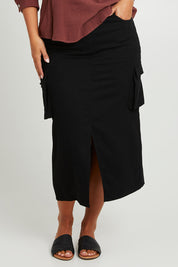 Model Monique wearing size 14 of the Carry Me With You Cargo Skirt in colour Black (Black), from the front, cropped image
