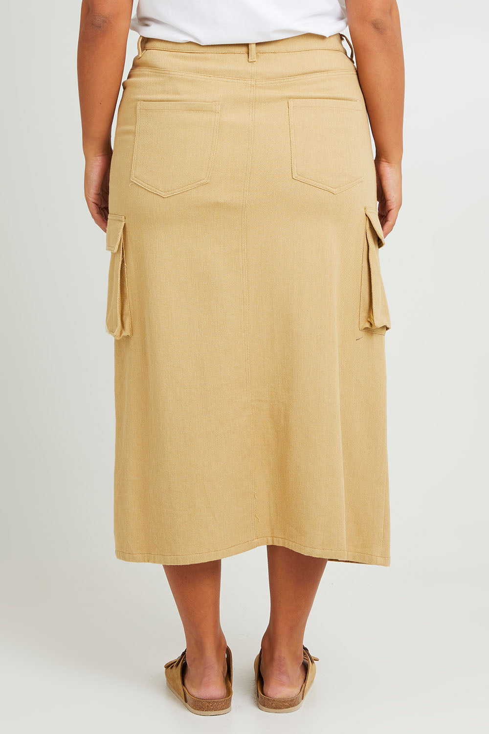 Model Monique wearing size 14 of the Carry Me With You Cargo Skirt in colour Sand, from the back