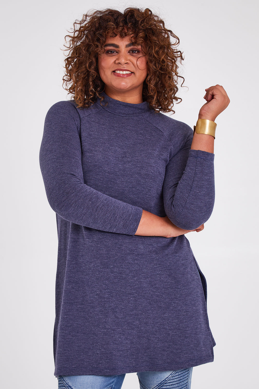 Model Anucia wearing size 14 of the Snuggle Up Tunic Top in colour Marldenim (Blue), from the front, cropped image