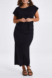 Model Monique wearing size 14 of the Coffee Run Skirt Set in colour Black (Black), from the front, cropped image