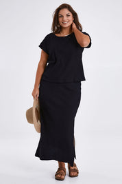 Model Monique wearing size 14 of the Coffee Run Skirt Set in colour Black (Black), from the front, showing the whole outfit