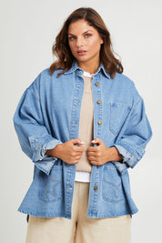 Model Monique wearing size 14 of the Good Times Oversize Denim Jacket in colour Denim (Blue), from the front, cropped image