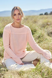 Model Tegan wearing size S of the Cover Me In Cotton Sweater in colour Sherbet (Pink), from the front, showing the whole outfit
