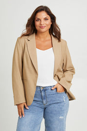 Model Monique wearing size 14 of the Sweet Whispers Blazer in colour Sand, from the front, cropped image