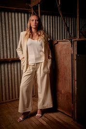 A model wearing the Elegant Persuasion Ruched Sleeved Oversized Blazer in colour Cream, from the front, showing the whole outfit