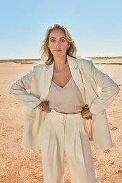 Model Tegan wearing size 10 of the Elegant Persuasion Ruched Sleeved Oversized Blazer in colour Cream, from the front, showing the whole outfit