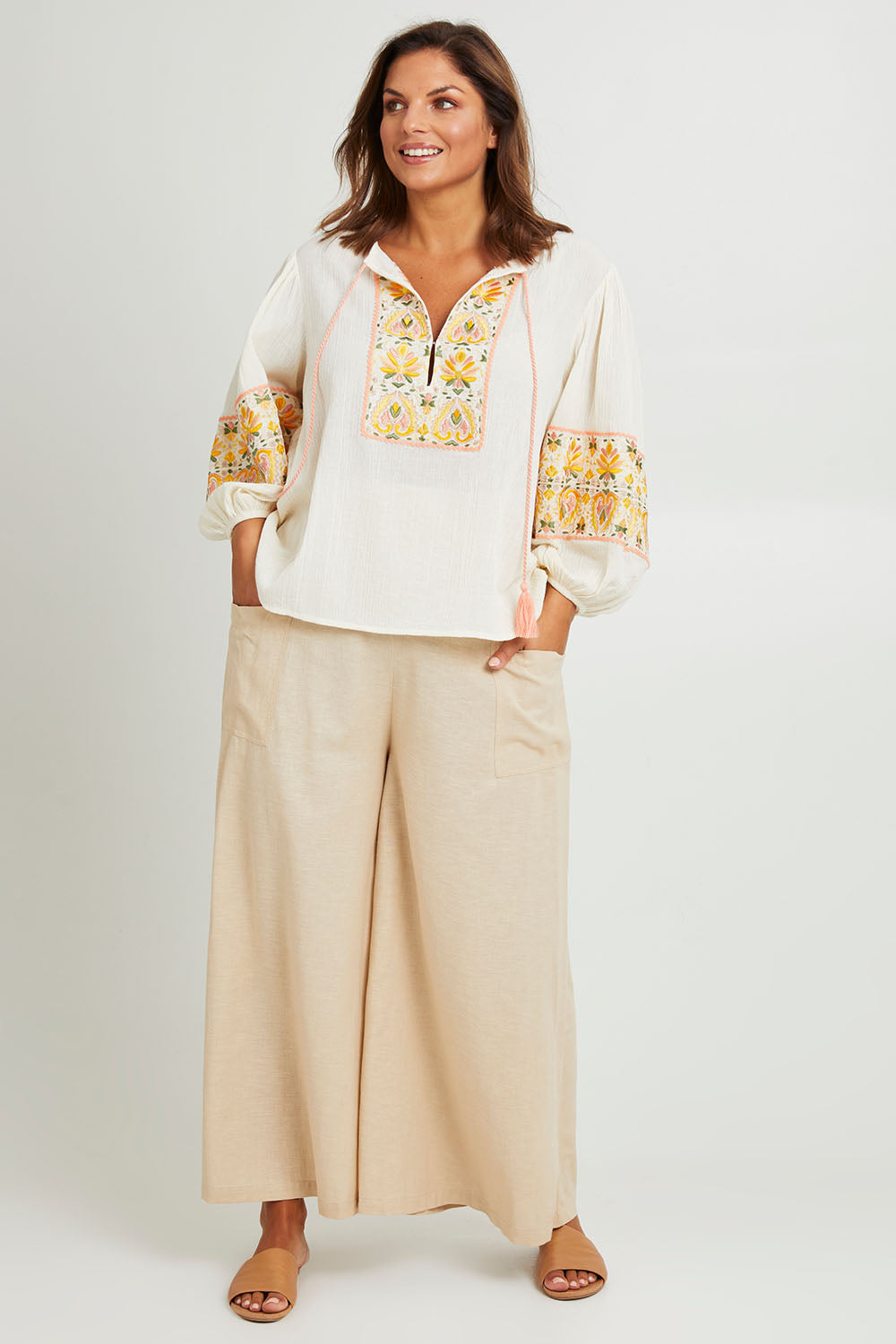 Model Monique wearing size 14 of the Serene Day Wide Leg Pants in colour Sand, from the front, showing the whole outfit