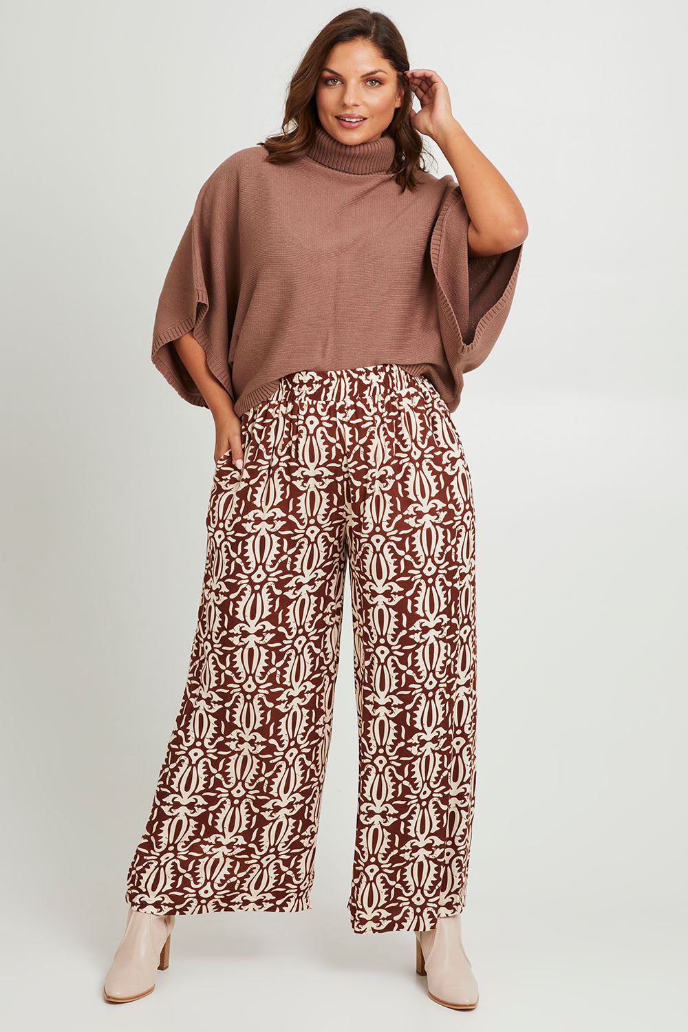 Model Monique wearing size 14 of the Swept Away By You Pant in colour Tribe, from the front, showing the whole outfit