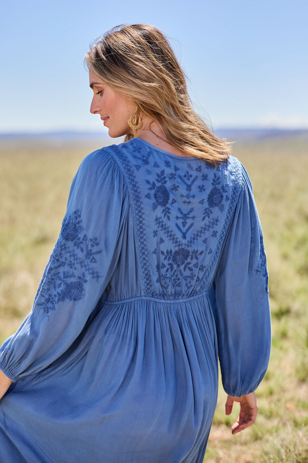Model Tegan wearing size 10 of the Through The Fields Dress in colour Ocean (Blue), from the back