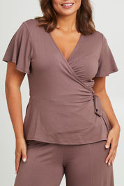 Model Monique wearing size 14 of the All For You Wrap Top in colour Tobacco, from the front, cropped image