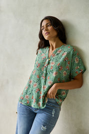 Model Tahnee wearing size 10 of the Flower Chain Slouch Top in colour Leaf (Green), from the front, showing the whole outfit