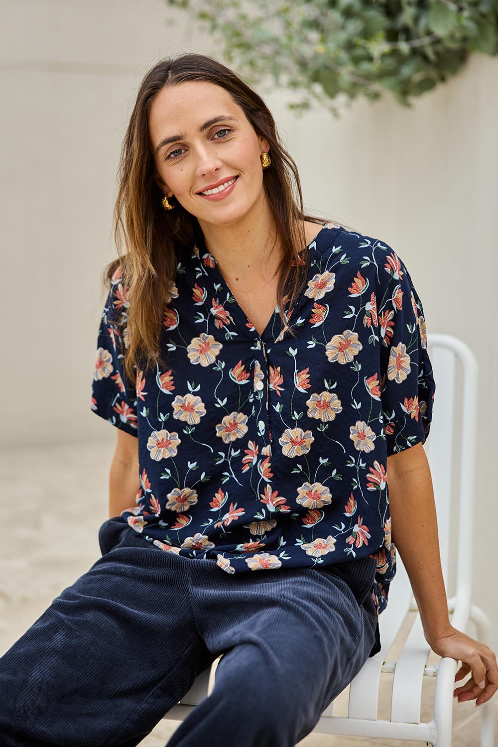 Model Tegand wearing size 10 of the Flower Chain Slouch Top – Navy in colour Navy, in a cropped view