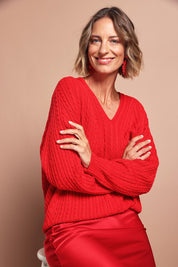 Model Riina wearing size S of the Ready And Cable Jumper in colour Firecraker (Red), from the front, showing the whole outfit