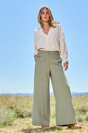 Model Tegan wearing size 10 of the Striding Out Wide Leg Pants in colour Thyme (Green), from the front, showing the whole outfit