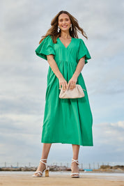Model Clementine wearing size 10 of the Lunch With The Girls Wrap Dress in colour Emerald (Green), from the front, showing the whole outfit