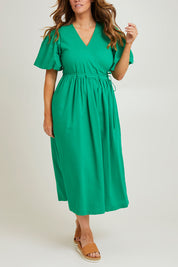 Model Laura wearing size 14 of the Lunch With The Girls Wrap Dress in colour Emerald (Green), from the front, cropped image