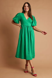 Model Madeline wearing size 10 of the Lunch With The Girls Wrap Dress in colour Emerald (Green), from the front, showing the whole outfit