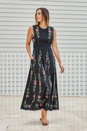 Model Tegand wearing size 10 of the Fleur Muse Embroidered Dress – Black in colour Black, from the front
