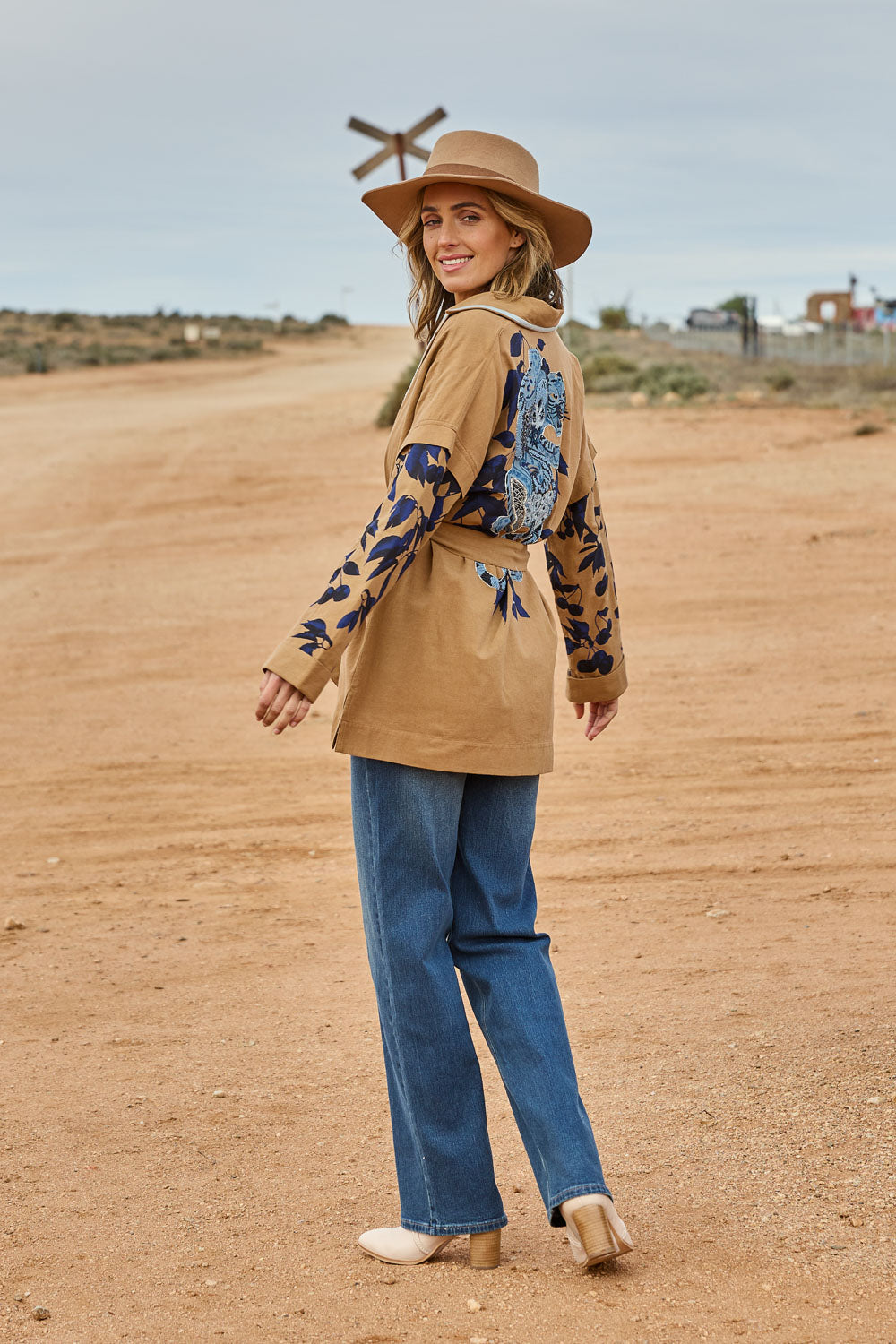 Model Tegan wearing size 10 of the Tigers Eye Cotton Jacket in colour Rust, from the front, showing the whole outfit
