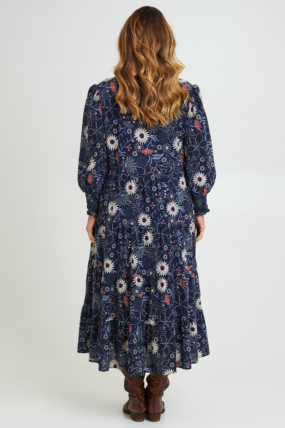 Model Laura wearing size 14 of the Falling Flowers Maxi Dress in colour Navyfleur (Blue), from the back
