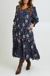 Model Laura wearing size 14 of the Falling Flowers Maxi Dress in colour Navyfleur (Blue), from the front, cropped image