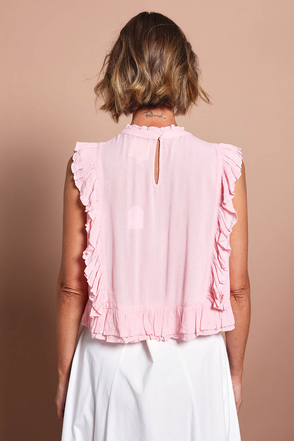 Model Riina wearing size 10 of the Easy Frills Embroidered Top in colour Blossom (Pink), from the back