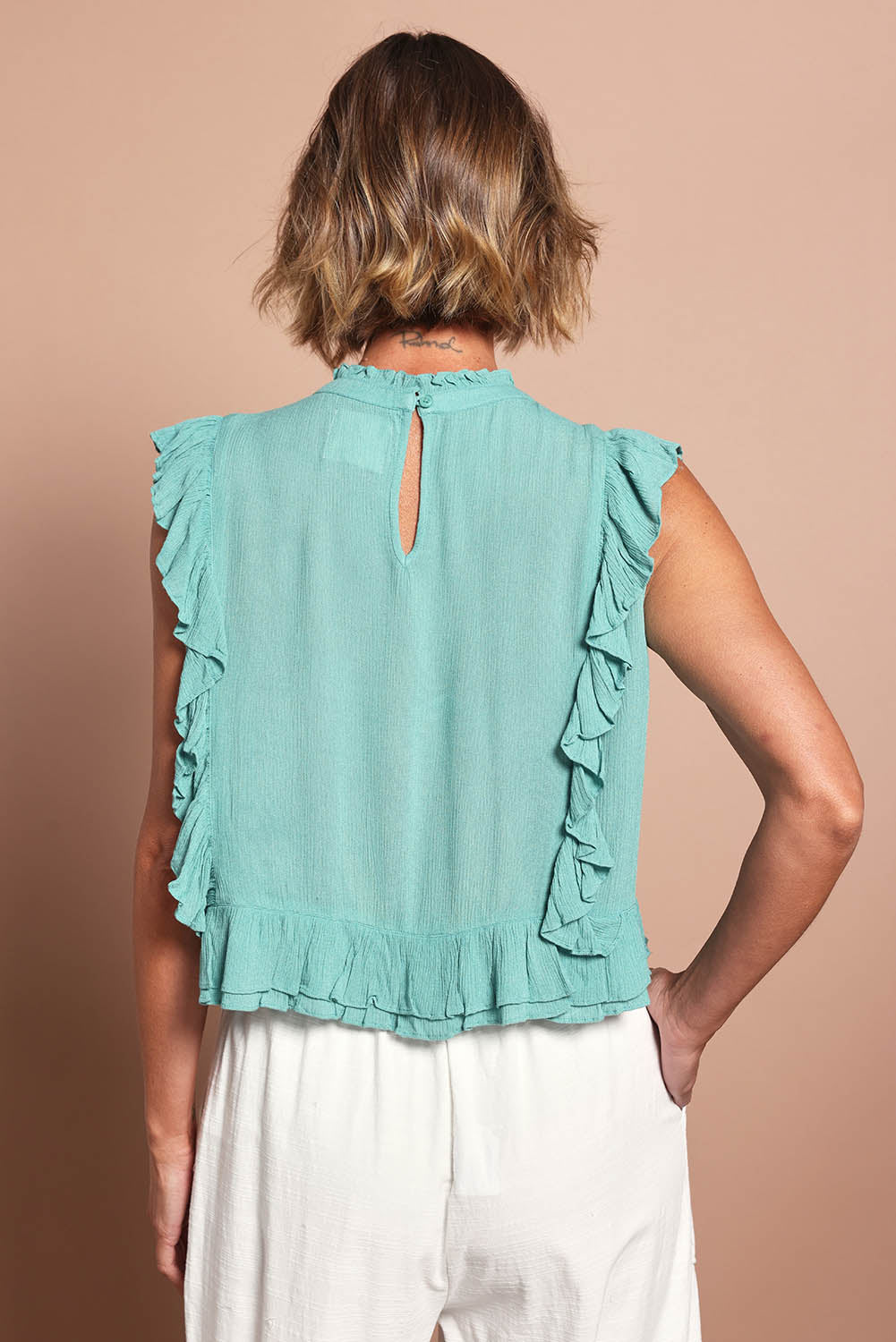 Model Riina wearing size 10 of the Easy Frills Embroidered Top in colour Pistachio (Green), from the back