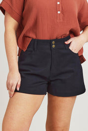 Model Jane wearing size 14 of the Too Good High Rise Denim Short in colour Black (Black), from the front, cropped image