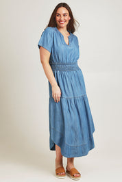 Model Jane wearing size 14 of the Beautiful Moments Dress in colour Chambray (Blue), from the front, showing the whole outfit
