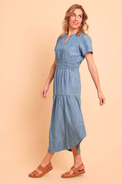 Model Olivia wearing size 10 of the Beautiful Moments Dress in colour Chambray (Blue), from the front, showing the whole outfit