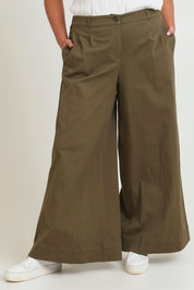 Model Chanel wearing size 16 of the Need You In My Life Pants in colour Moss (Green), from the front, cropped image